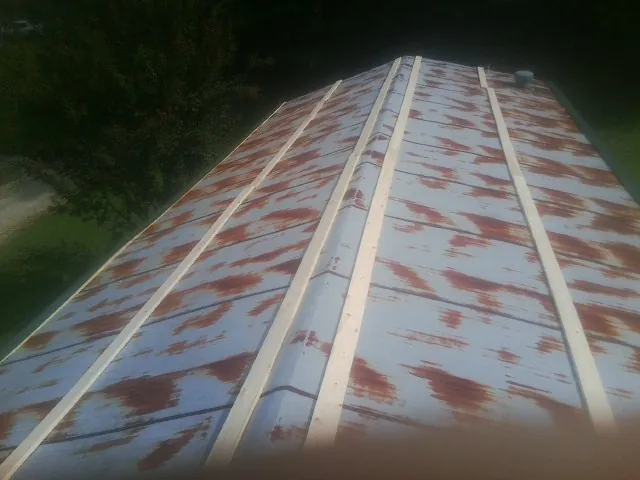 Rusted metal roof panels with new wood purlins before replacement — Storm Damage Roof Repair in Purlear by Roofing Brothers