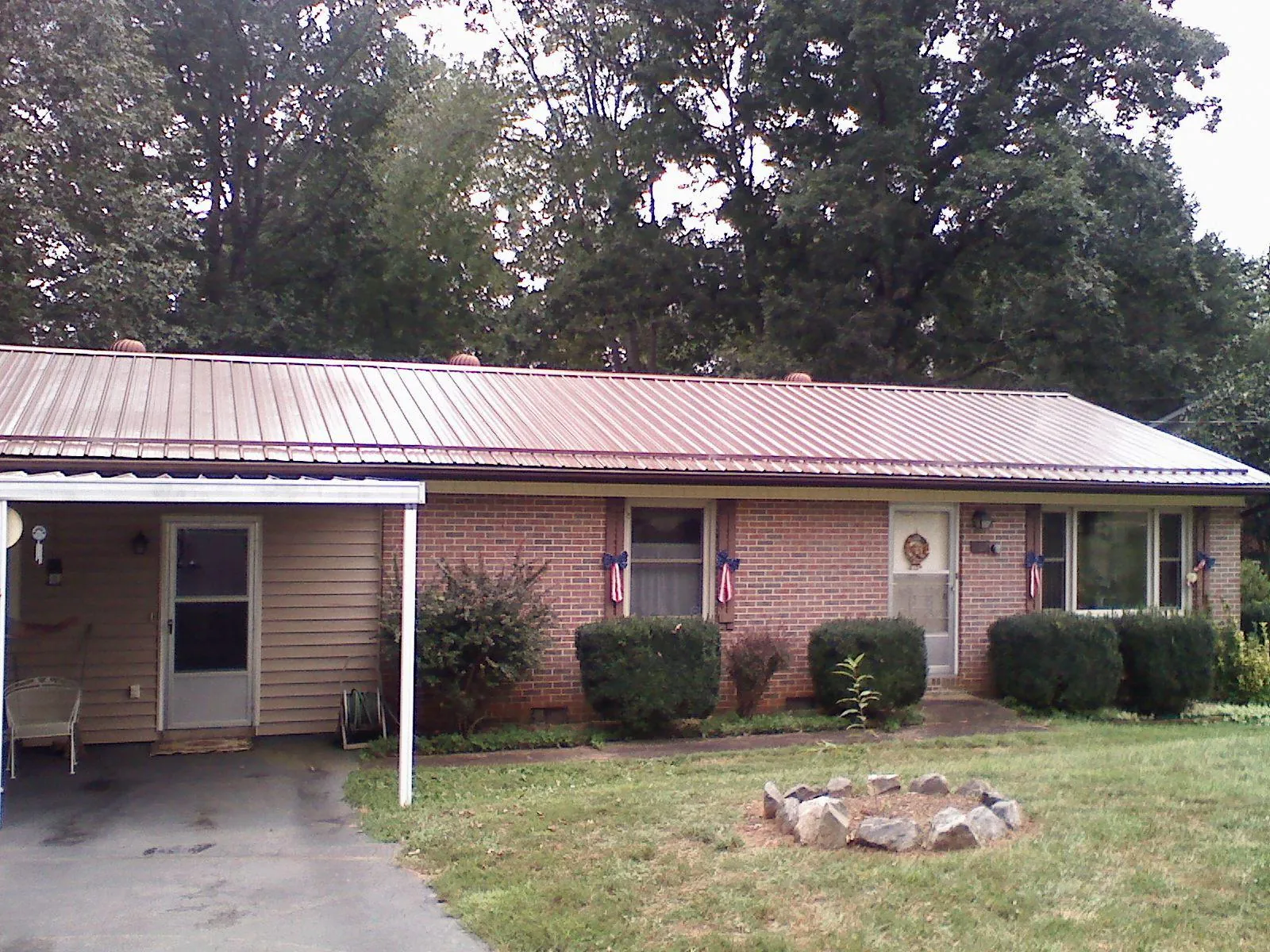Bronze metal roof and carport on a brick ranch home — Roof Repair work by our crew in Purlear