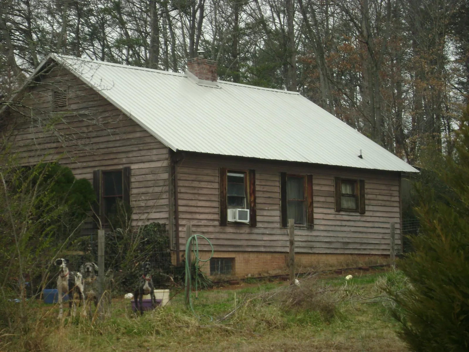 White metal roof on an old wood sided farmhouse, from a Metal Roof Installation job in Purlear